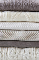 Stack of warm cozy light sweaters