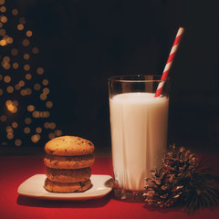 Christmas cookies milk note for Santa in front of lights new year tree