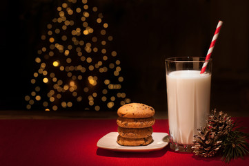 Christmas cookies milk note for Santa in front of lights new year tree