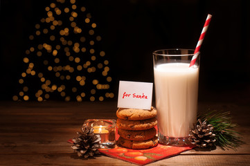 Christmas cookies milk note for Santa in front of lights new year tree
