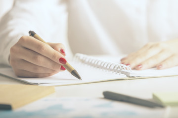 Woman writing in notepad