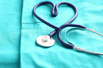 stethoscope shaping  heart and  clipboard on  medical uniform, closeup