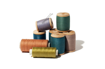 Spool of thread and needle isolated on white background