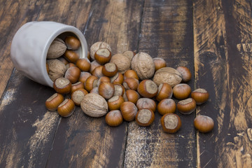 Hazelnuts and walnuts  in bowl on brown wooden table
