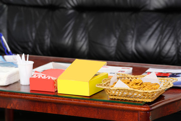 Interior of an empty visitor room in business center with skin furniture in it and served table