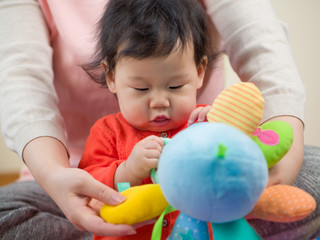 Fototapeta na wymiar Asian baby girl playing toy with mom