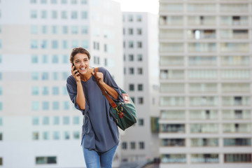 Cheerful city woman talking on mobile phone