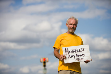 Homeless man with a sign asking for help.