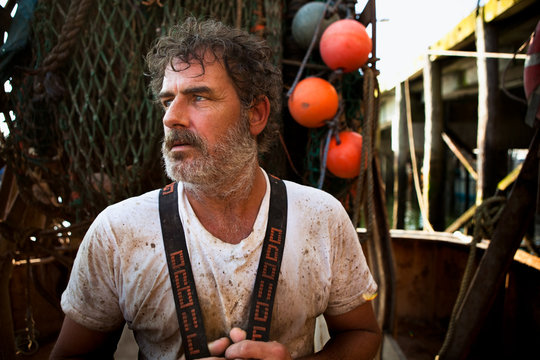 Portrait of a dirty, hard working, fisherman on boat in Portland, Maine