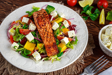 Fried Salmon steak with fresh vegetables salad. concept healthy food.