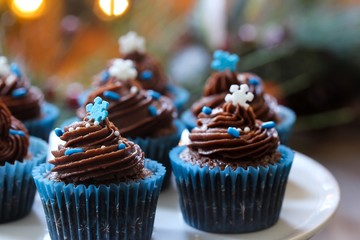 Homemade Christmas Chocolate cupcakes with buttercream frosting on holiday background