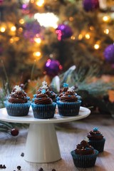 Homemade Christmas Chocolate cupcakes with buttercream frosting on holiday background