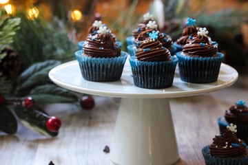 Homemade Christmas Chocolate cupcakes with buttercream frosting on holiday background