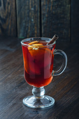 Mulled wine with cinnamin and orange on dark background