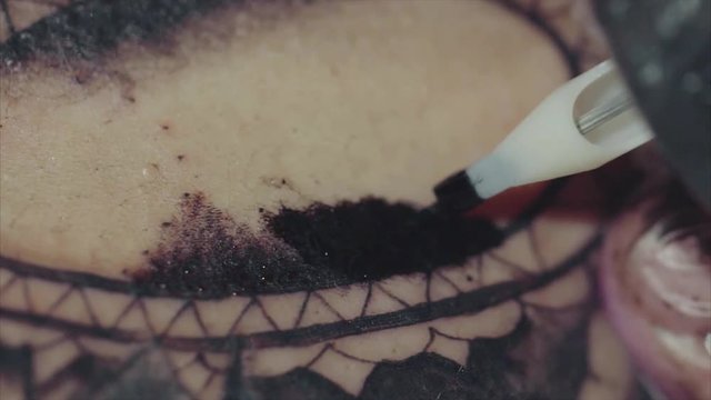 Close-up of tattoo machine tattooing a pattern on body macro HD