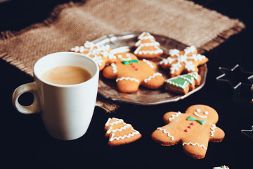 Beautiful Christmas background cookies and cap of coffee on dark background
