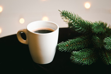 Beautiful Christmas background with branch of fir tree and a white Cup of coffee