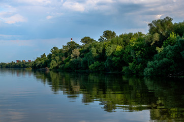 Fototapeta premium Reflection of trees and sky in river