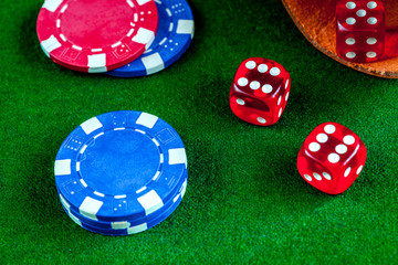 poker chips and dice on green background top view