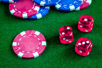 poker chips and dice on green background top view