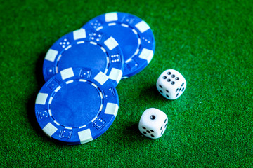 poker chips and dice on green background top view