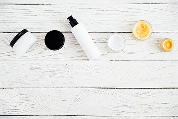 Top view of  various cosmetics jars, branding mock-up for body and skin care creams on a whitewash...