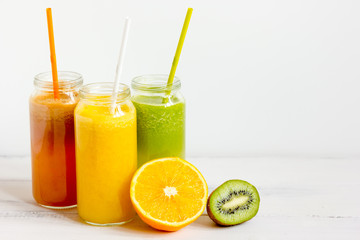 Fresh detox juices in glass bottles on white background