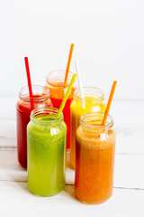 Fresh detox juices in glass bottles on white background