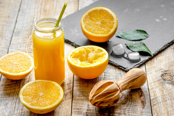 freshly squeezed orange juice in glass bottle on wooden background