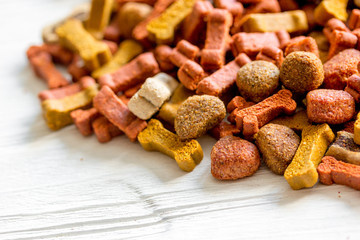 dry dog food in bulk on wooden background close up