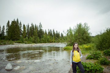 Female tourist standing beside the mountain river