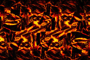Smoldering ashes of a bonfire. incandescent orange and red embers texture. Concept from alfaphoto