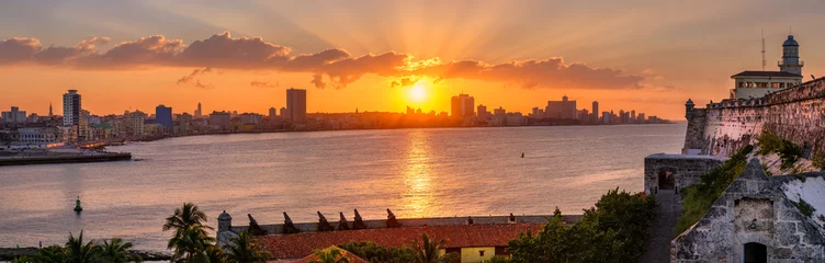 Photo sur Aluminium Havana Coucher de soleil à La Havane avec le coucher de soleil sur les bâtiments en bord de mer, y compris une vue sur le phare d& 39 El Morro