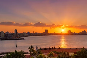 Gordijnen Beautiful sunset in Havana with the sun setting over the seaside buildings © kmiragaya