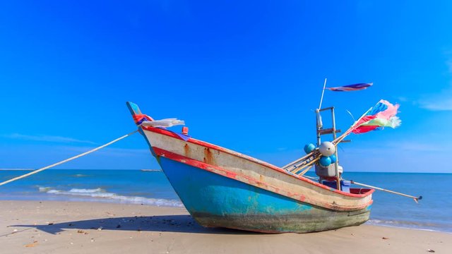 the alone fishing boat on the beach with blue sky in Thailand ocean