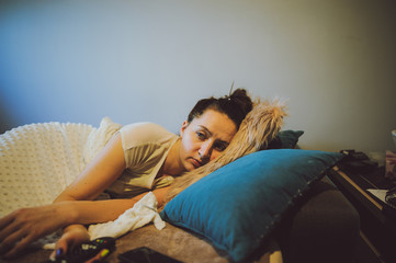 sick woman lying in bed with headache