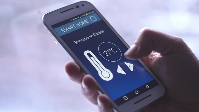 Changing the temperature of the house directly on a smartphone. Winter background.