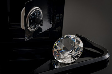 Home invasion and burglary concept with crowbar and a diamond outside a opened safety box or safe