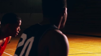 A basketball player shooting a free throw, slow motion, dark