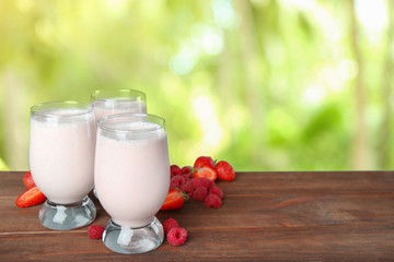 Glasses of delicious cocktails on wooden table