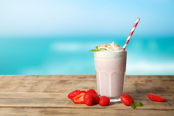 Glass of delicious cocktail on wooden table
