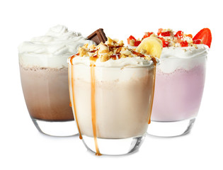 Glasses with delicious milk shakes on white background.
