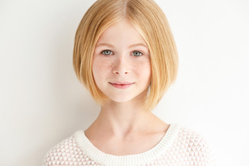 Portrait of attractive teenager girl with freckles on white background