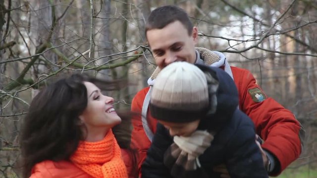 Young family in the woods. Mom shows the knar to his son.