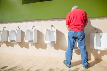 a man peeing standing up in the restroom
