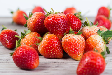 Strawberries with leaves on a wooden background