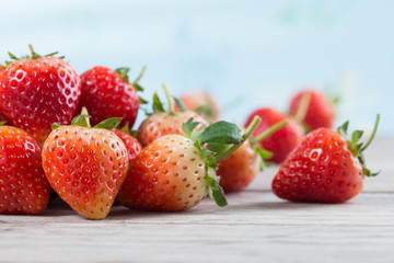 Strawberries with leaves on a wooden background