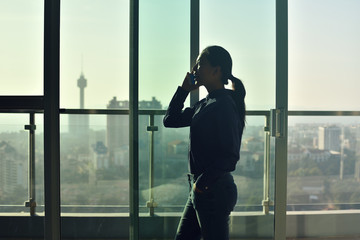 Silhouette of Business woman standing  against the backdrop of l