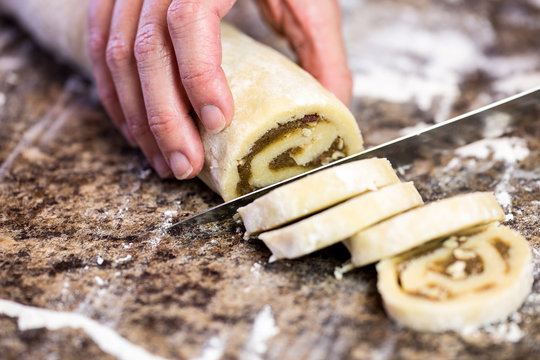 Close Up Of Slicing Butter Pecan Cookies With Hand And Kife