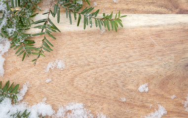 Wooden board with hemlock evergreen and snow along borders with room for text background